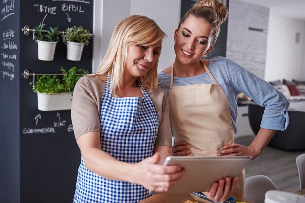 Gratis foto moeder en dochter kijken naar recept op een tablet