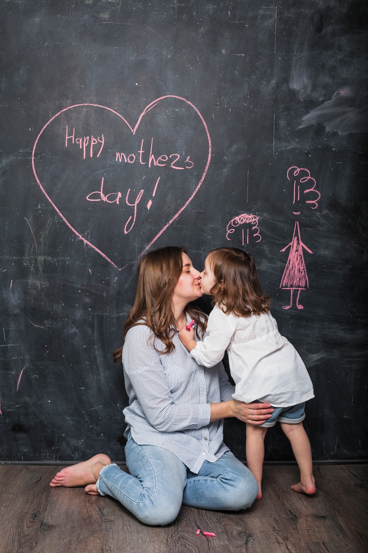 Gratis Foto moeder en dochter kussen in de buurt van happy mothers day inscriptie