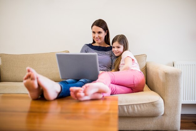 Moeder en dochter met behulp van laptop in de woonkamer