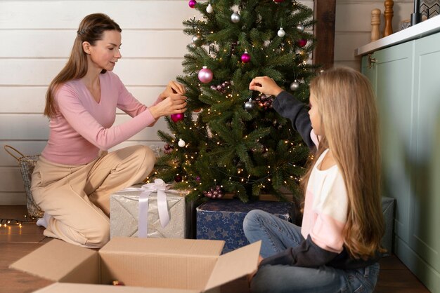 Moeder en dochter versieren de kerstboom