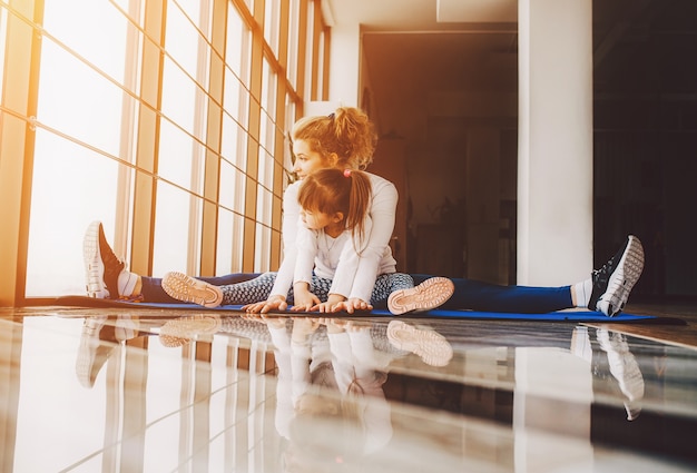 Moeder en dochter zitten op de vloer doen yoga