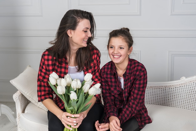 Moeder en dochter zittend op de Bank met tulpen