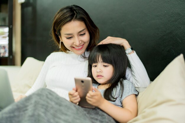 Moeder en dochter zoeken samen online op het bed 's ochtends tijd