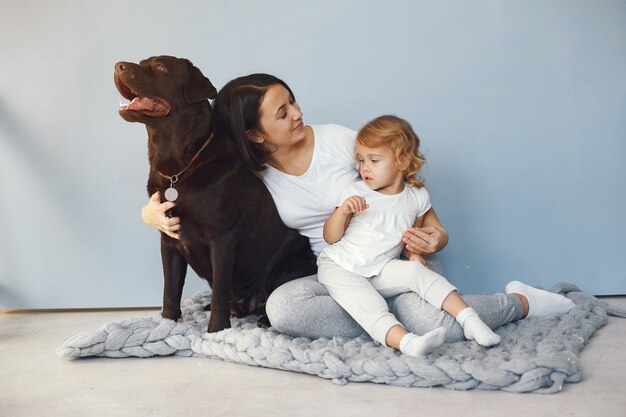 Moeder en dochtertje spelen met hond thuis