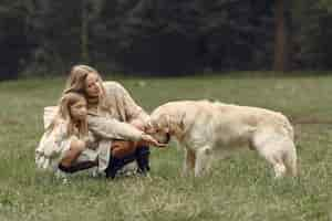 Gratis foto moeder en haar dochter spelen met hond. familie in de herfstpark. huisdier, huisdier en levensstijl concept