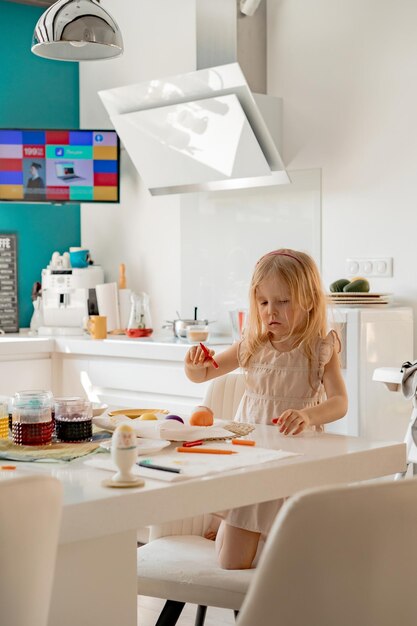 Moeder en haar dochters schilderen eieren. Gelukkige familie die zich voorbereidt op Pasen.