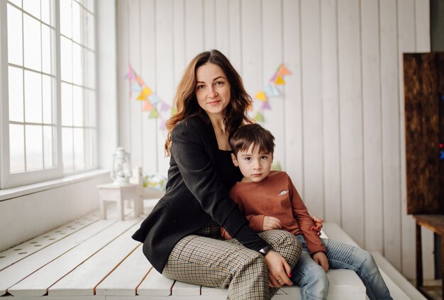 Moeder en haar zoon poseren in de studio en dragen vrijetijdskleding