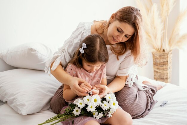 Moeder en jonge dochter boeket van Lentebloemen houden