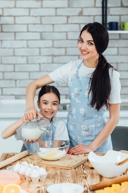Moeder en kind dochter meisje koken koekjes en hebben plezier in de keuken