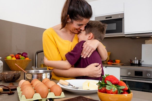 Moeder en kind knuffelen in de keuken