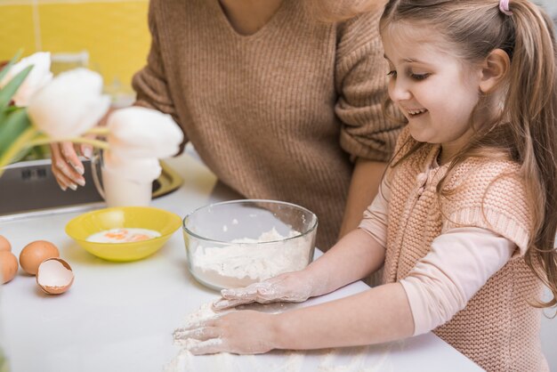 Moeder en schattige dochter koken in de keuken