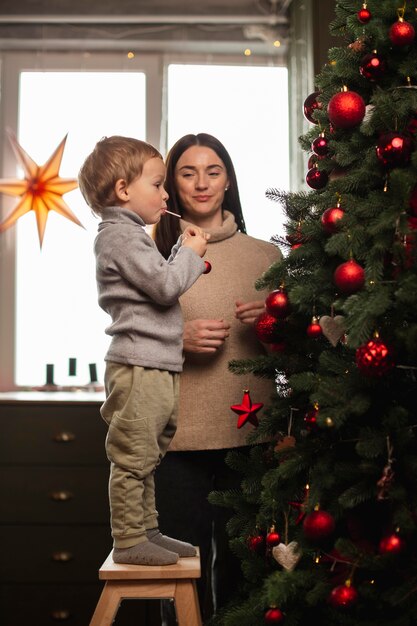 Moeder en zoon die de kerstboom versieren
