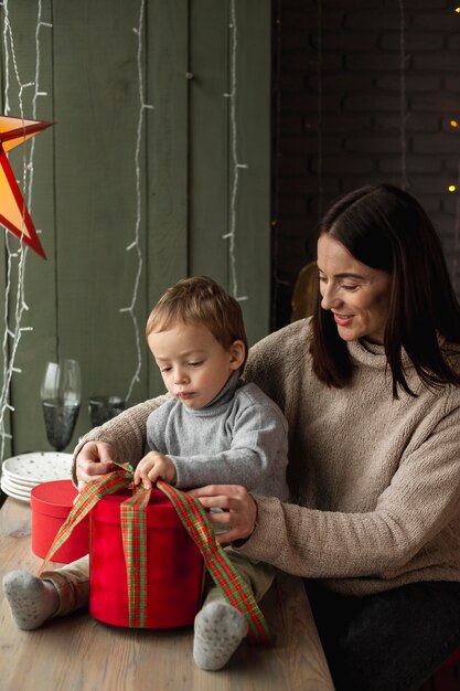 Moeder en zoon die kerstcadeau openen