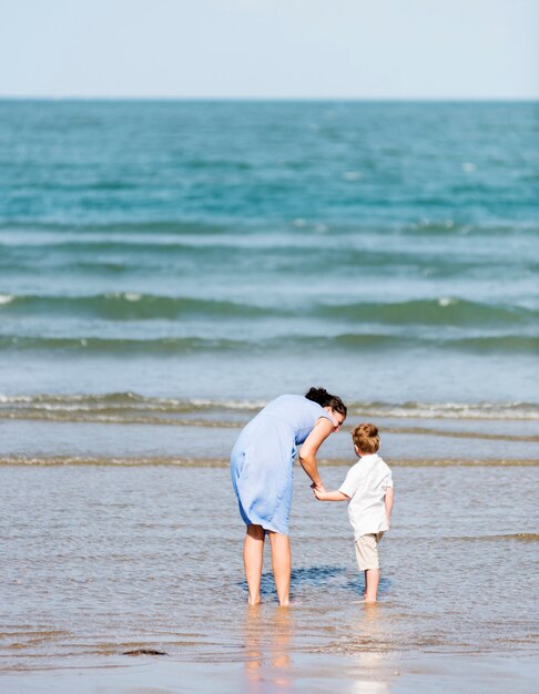 Moeder en zoon die op het strand koelen