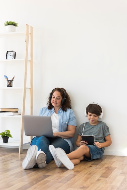 Moeder en zoon die op laptop kijken