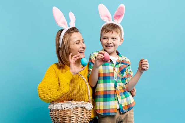 Moeder en zoon houden mand met beschilderde eieren