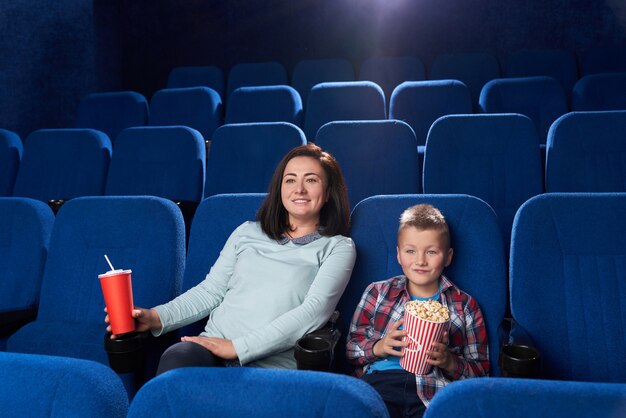 Moeder en zoon kijken naar film in de bioscoop.