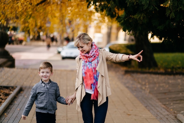 moeder en zoon lopen buiten in de herfst