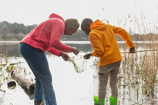 Moeder en zoon lopen door een modderige locatie