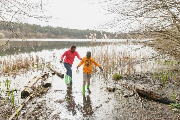 Moeder en zoon lopen door een modderige locatie