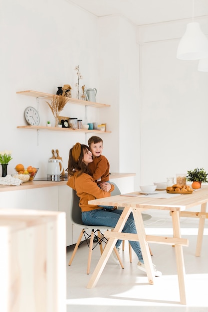 Moeder en zoon op stoel knuffelen