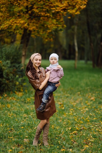 Moeder en zoon wandelen en plezier samen in het herfstpark.