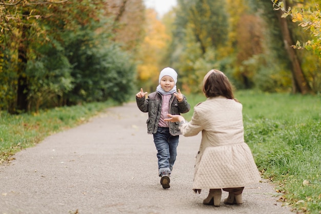 Moeder en zoon wandelen en plezier samen in het herfstpark.