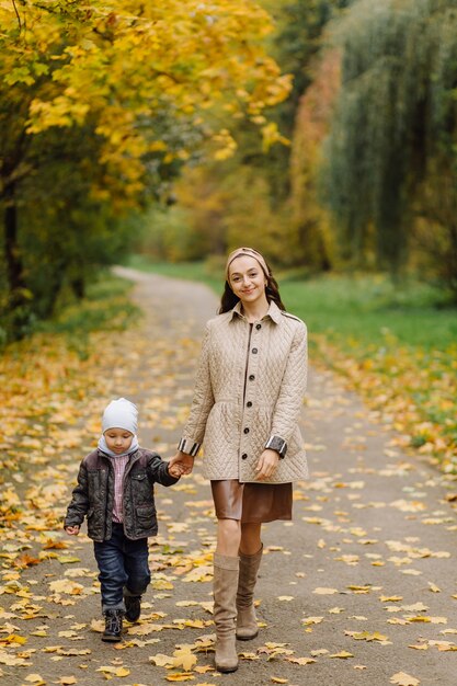 Moeder en zoon wandelen en plezier samen in het herfstpark.