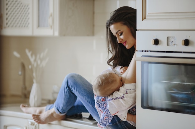 moeder geeft borstvoeding in de keuken