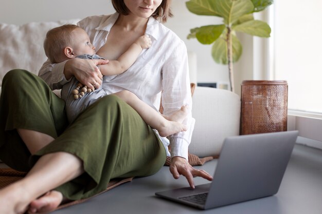 Moeder geeft haar kind borstvoeding tijdens het werken