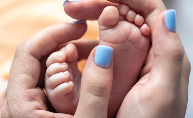Gratis foto moeder houdt de benen van een pasgeboren baby in haar handen