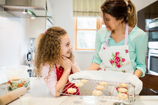 Moeder in interactie met dochter terwijl cookies in coolin