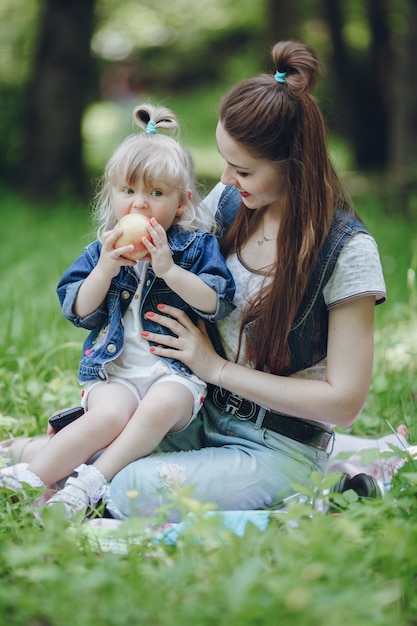 Moeder kijkt haar dochter terwijl het eten van een appel