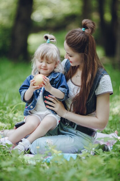 Moeder kijkt haar dochter terwijl het eten van een appel