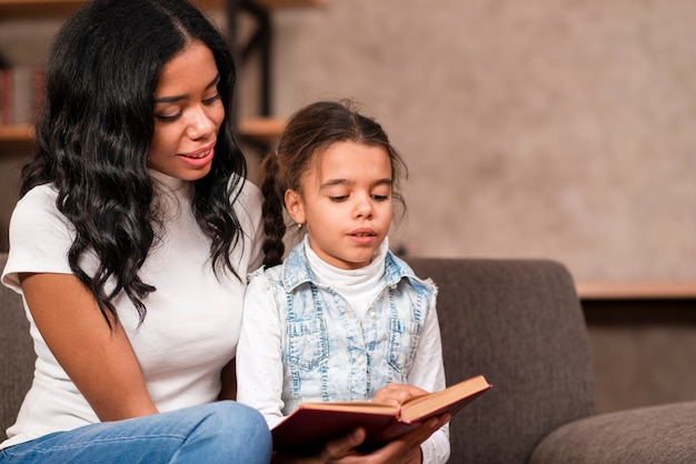 Gratis foto moeder luistert haar dochter tijdens het lezen