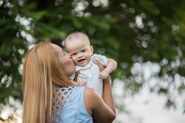 Moeder met baby, lachen en spelen in het park