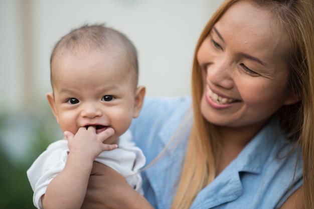 Moeder met baby, lachen en spelen in het park