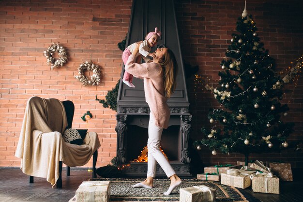 Moeder met dochter bij de open haard op Kerstmis