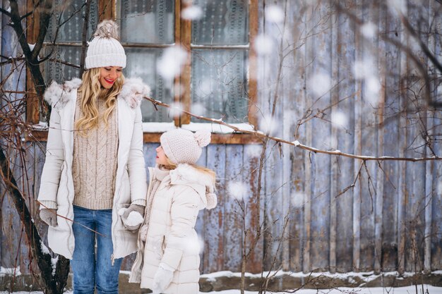 Moeder met dochter die samen in een de winterpark loopt