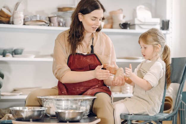 Moeder met dochter maakt vaas in een pottenbakkerij