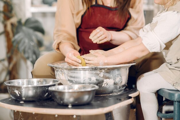 Moeder met dochter maakt vaas in een pottenbakkerij