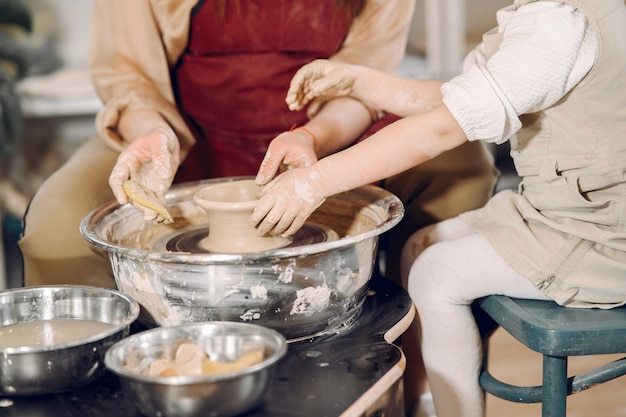 Moeder met dochter maakt vaas in een pottenbakkerij