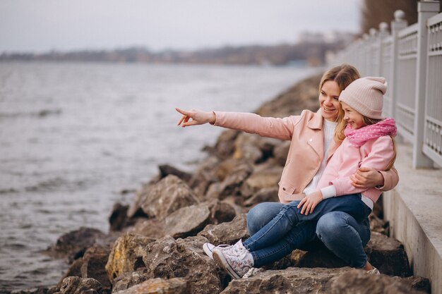 Moeder met dochter zit aan het meer