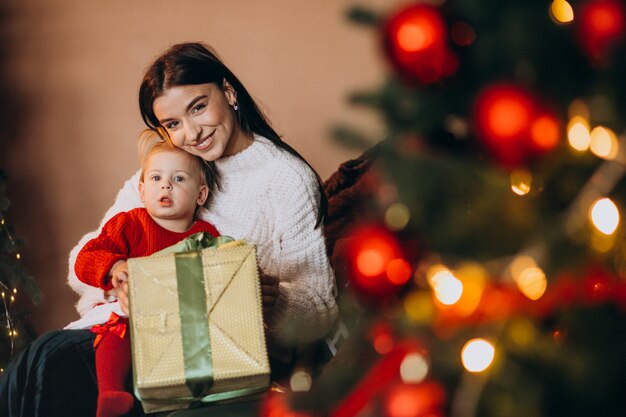 Moeder met dochterzitting door de Kerstboom