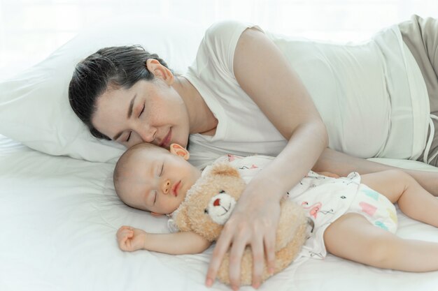 Moeder met haar babyslaap op slaapkamer