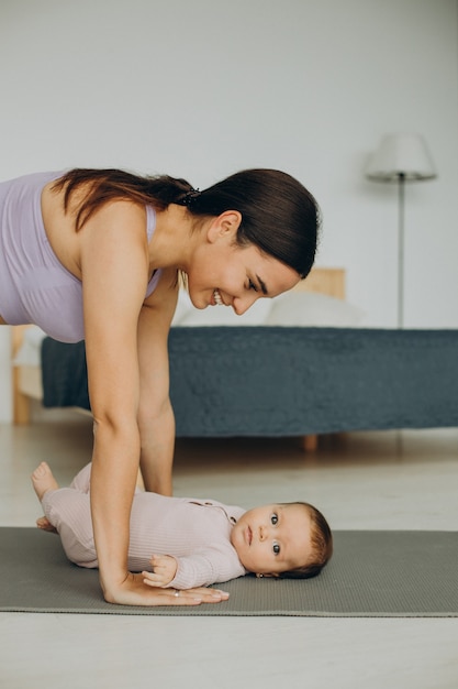 Moeder met haar dochtertje beoefent thuis yoga