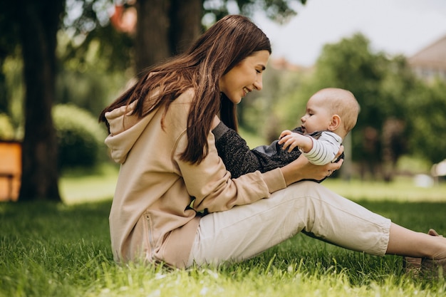 Moeder met haar zoontje in park zittend op het gras