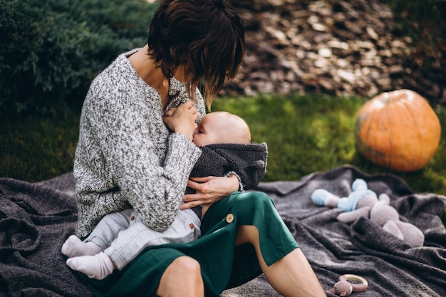 Moeder met haar zoontje met picknick op een achtertuin