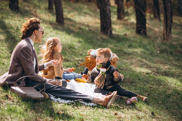 Moeder met jonge geitjes die picknick in het bos hebben