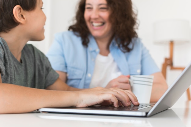 Moeder met kind dat aan laptop werkt